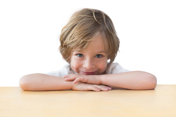 Closeup of adorable little boy on the table edge, smiling