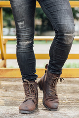 Men fashion, man's legs in black jeans and brown leather boots.