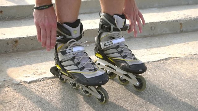 Man preparing for roller skating, putting on rollerskates HD