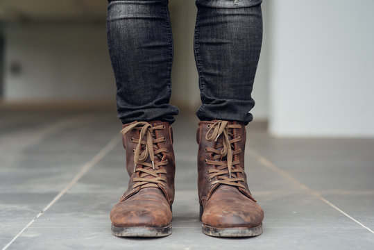 Close up view on man's legs in black jeans and brown leather boots.Toned picture.