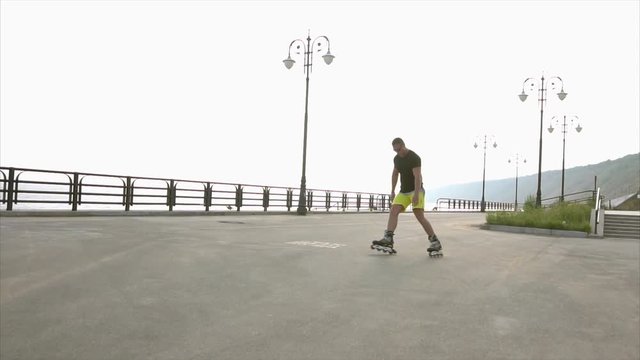 Young sporty man learns to roller skate on waterfront HD