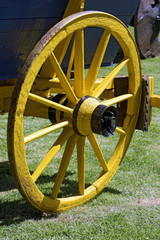 Fototapeta na wymiar Yellow wheel of ancient wagon
