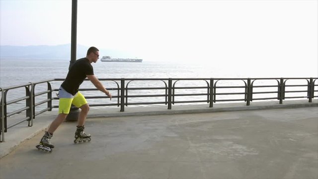 Sporty man roller skating on waterfront and falling while trying to jump HD
