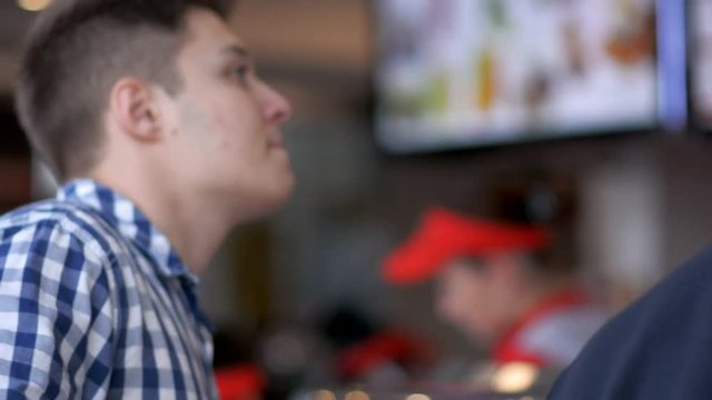 Man buying fastfood at fast-food restaurant