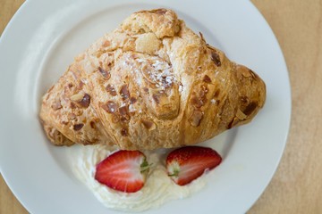 Close-up of croissant and strawberry on plate