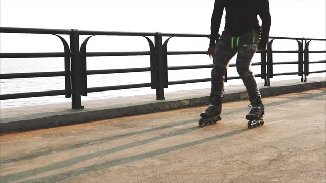 Mans legs roller skating inline close up on the asphalt sunset HD