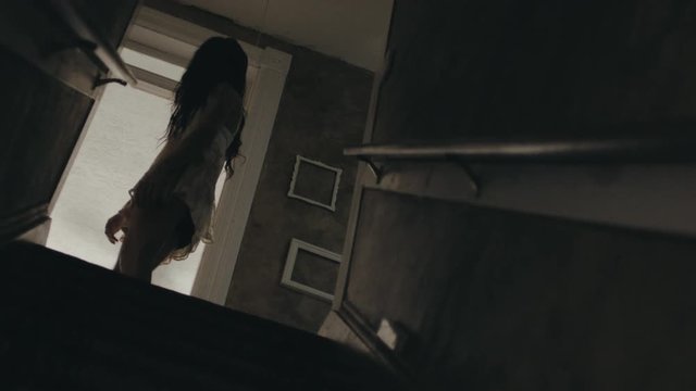 Creepy Girl Walking Past a Dark Staircase