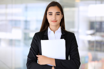 Young brunette businesswoman or student girl looking at camera