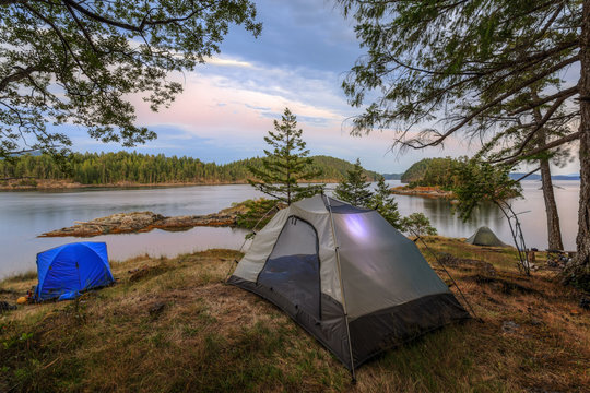 Kayakers camp on Penn Island in Sutil Channel between Read and Cortes Islands British Columbia Canada.