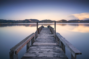 Jetée ou jetée en bois sur un lac bleu coucher de soleil et réflexion sur le ciel