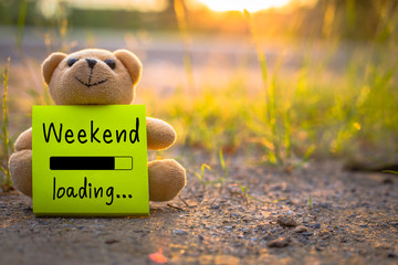 Happy Weekend on sticky note with teddy bear on nature background - obrazy, fototapety, plakaty
