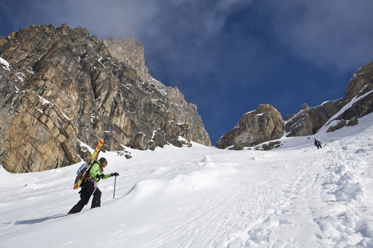 A female backcountry skier bootpacks up a steep slope while on a backcountry ski hut trip in the canadian rockies near Golden, British Columbia, Canada