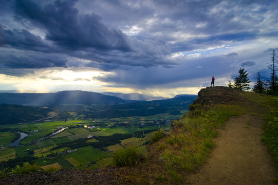 Hiker revels in the view after a challenging, yet rewarding hike to the top of the Enderby Cliffs, overlooking Enderby, in the Okanagan/Shuswap region of British Columbia, Canada