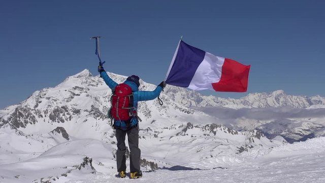 French mountaineer celebrates on mountain peaks.