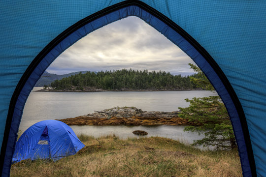 Kayakers camp on Penn Island in Sutil Channel between Read and Cortes Islands British Columbia Canada.