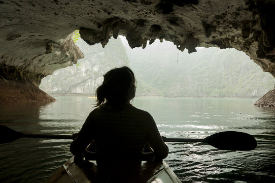 Kayaking through a rock arch in Lan Ha Bay, Vietnam