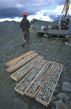 Drill rig operator taking drill pipe back to rig, Yukon Territory, Canada