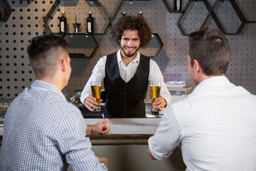 Bartender serving beer to customers
