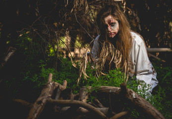 Scary and bloody zombie woman at the backyard. Halloween concept