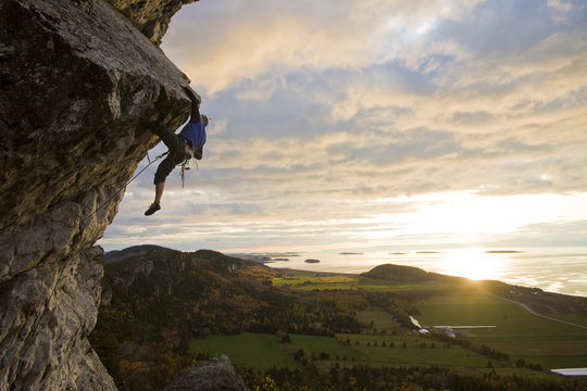 A young man climbs the popular route Moby Dick 5.11b, Kamouraska, QC