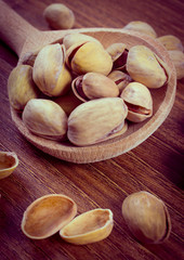 Vintage photo, Pistachio nuts with spoon on wooden table, healthy eating