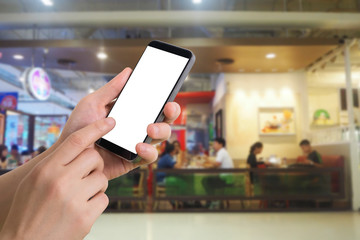 human hand hold and touch smartphone with blank screen on blurred people eating at food court background.