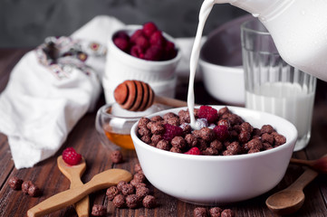 corn balls breakfast with milk being poured over it © YuliiaMazurkevych