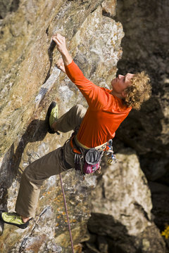 A young man climbs Lune de jour 5.9, Mt Orford, Quebec