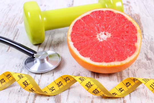 Fresh grapefruit, centimeter, stethoscope and dumbbells, healthy lifestyles
