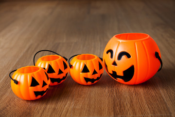 Group of happy and smiling jack-o-Lantern pumpkin buckets on wooden background