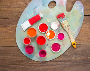 Paints, brushes and palette on the wood background. The workplace of the artist. Banner for school