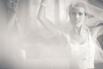 Happy bride raises her hands while looking in the mirror