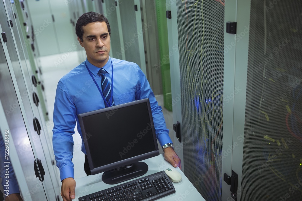 Poster technician walking with personal computer in hallway