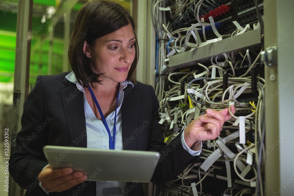 Poster Technician using digital tablet while analyzing server
