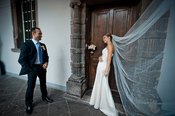 Bride and groom look at each other while standing before old woo