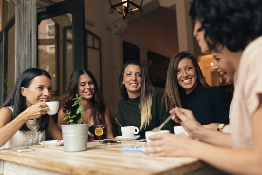 Smiling women having coffee and chatting
