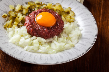 Steak tartare with egg yolk, onions and pickles