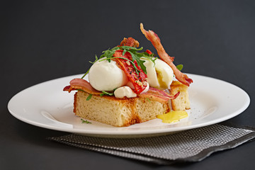 Breakfast of soft-boiled egg, bacon and tomato