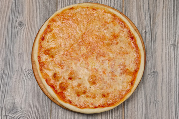 Pizza margherita on wooden table, top view.
