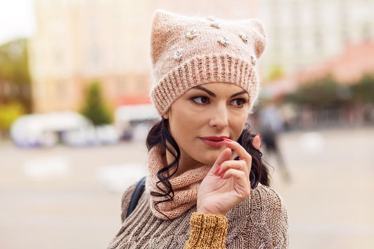Woman's face in a knitted cap with a scarf, an autumn portrait