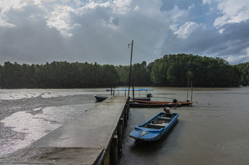 Boats at  harbour  bridge while It is raining hard and The sun shining, Khlung, Chanthaburi, Thailand.