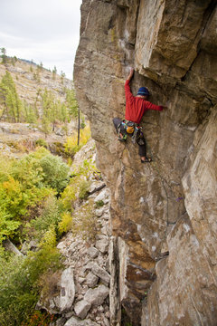 A man traditional rockclimbing the route Malpractice 10d, Skaha, BC