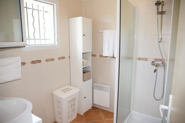 Fototapeta na wymiar Modern bathroom with white ceramic appliances and shower cabin