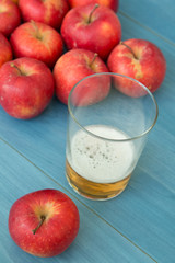 Ripe red apples with a glass of cider