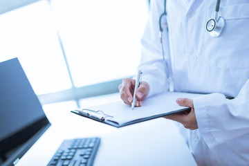 Close-up view of female doctor hands filling patient registratio
