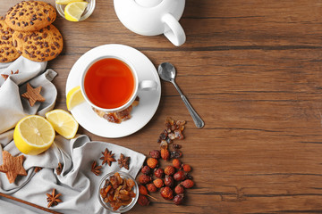 Ingredients for tea drinking on wooden background, flat lay
