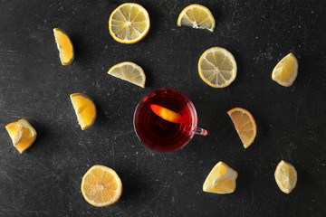 Cup of fresh tea with slices of lemons around, top view