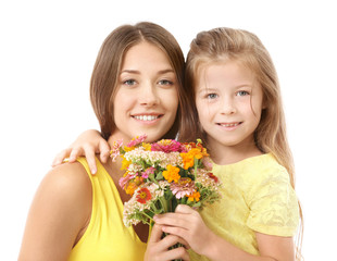 Fototapeta na wymiar Cute girl with mother and bouquet of flowers on white background