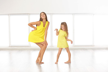 Cute girl with mother on light window background