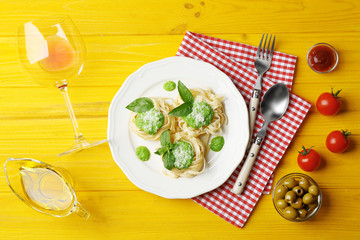 Delicious tagliatelle pasta with ingredients on wooden table